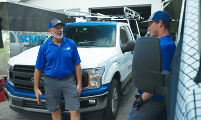 men talking outside a car