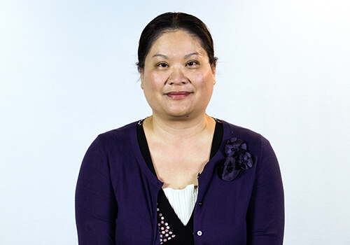 A picture containing person, posing, smiling, purple
Description automatically generated